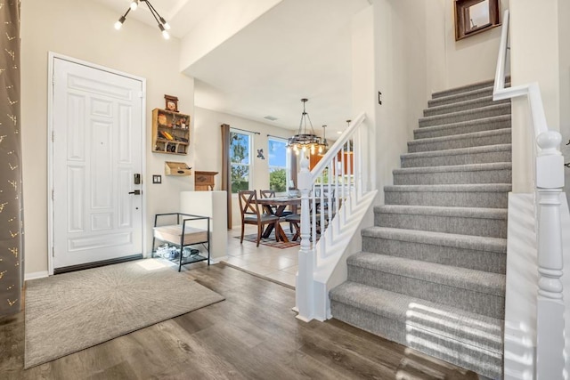 foyer entrance with an inviting chandelier and wood-type flooring