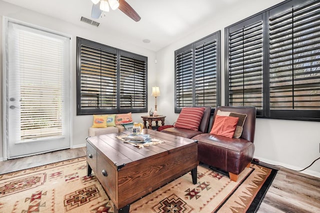 living room featuring ceiling fan and light hardwood / wood-style floors