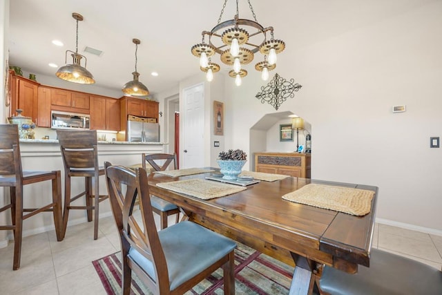 tiled dining space featuring a notable chandelier