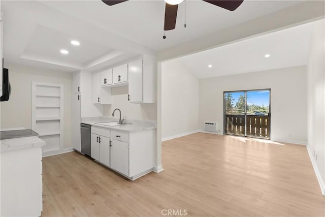 kitchen featuring a sink, white cabinetry, open floor plan, light countertops, and dishwasher