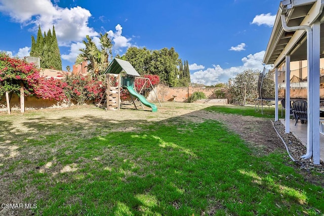 view of yard featuring a playground and a trampoline