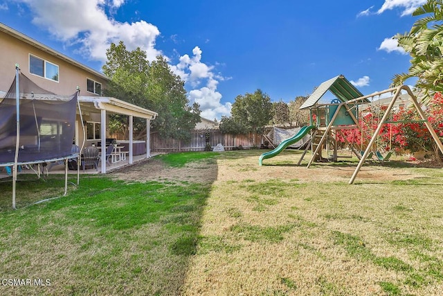 view of yard with a trampoline and a playground