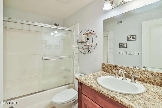 full bathroom with toilet, bath / shower combo with glass door, and vanity