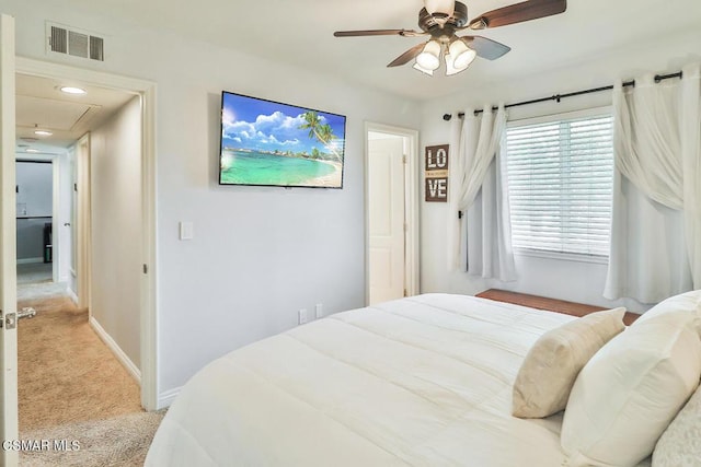 bedroom with ceiling fan, multiple windows, and light carpet