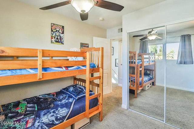 carpeted bedroom with ceiling fan and a closet