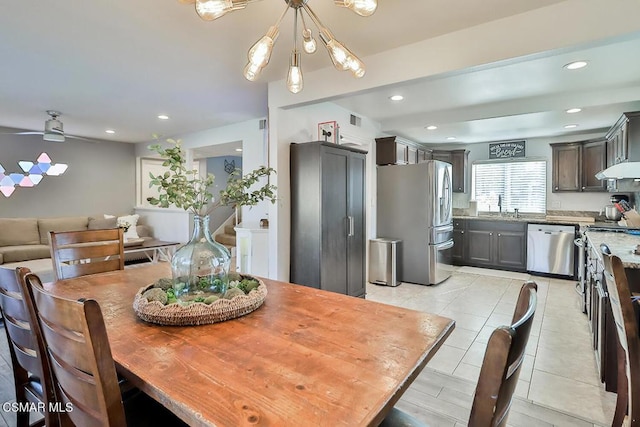 tiled dining area with ceiling fan and sink