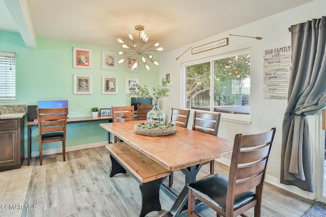 dining area featuring beam ceiling, a chandelier, and light wood-type flooring