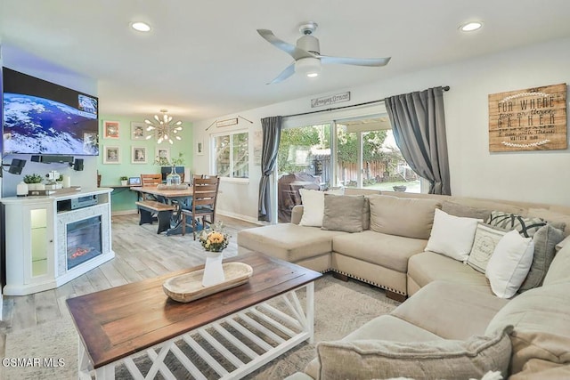 living room with ceiling fan and light hardwood / wood-style flooring