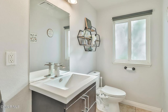 bathroom with toilet, a wealth of natural light, tile patterned flooring, and vanity