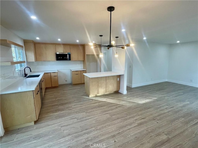 kitchen featuring hanging light fixtures, a notable chandelier, sink, and light hardwood / wood-style floors