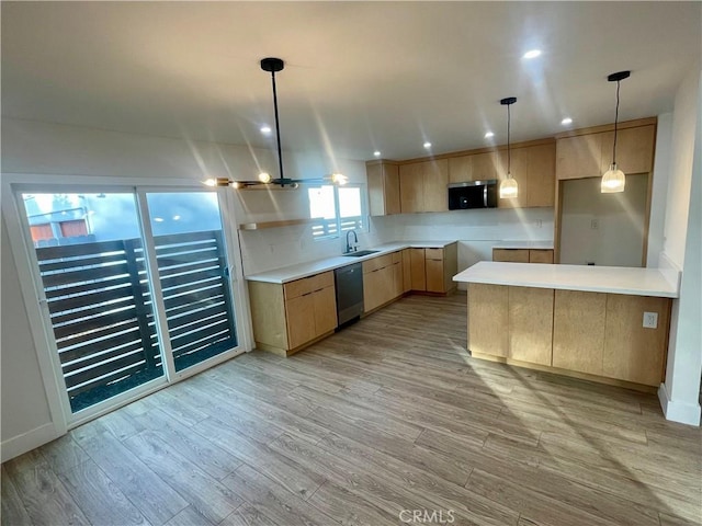 kitchen with appliances with stainless steel finishes, light brown cabinetry, sink, hanging light fixtures, and light wood-type flooring