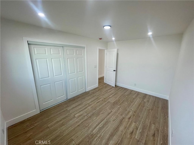 unfurnished bedroom featuring a closet and light hardwood / wood-style floors