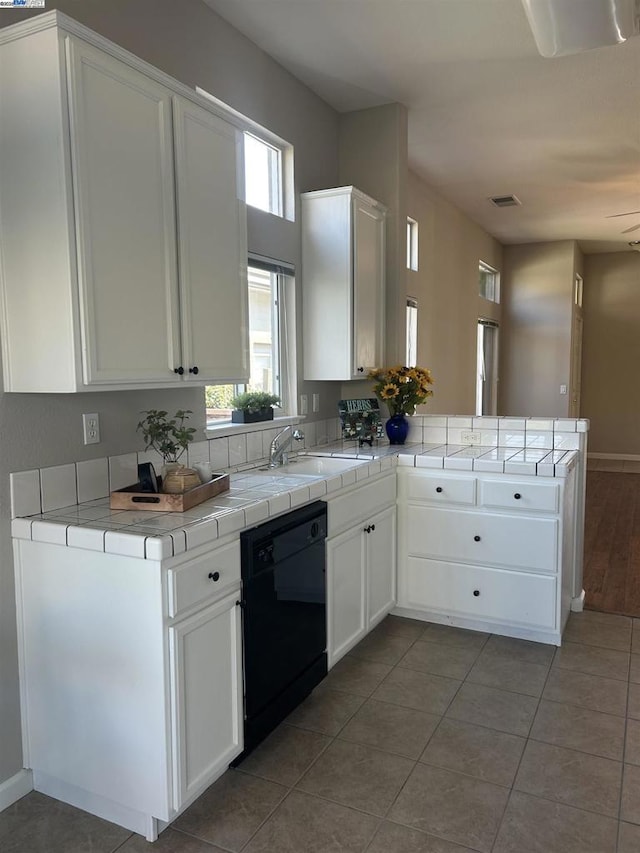 kitchen featuring kitchen peninsula, white cabinetry, dishwasher, and tile countertops