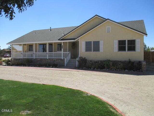 ranch-style home with a front lawn and covered porch