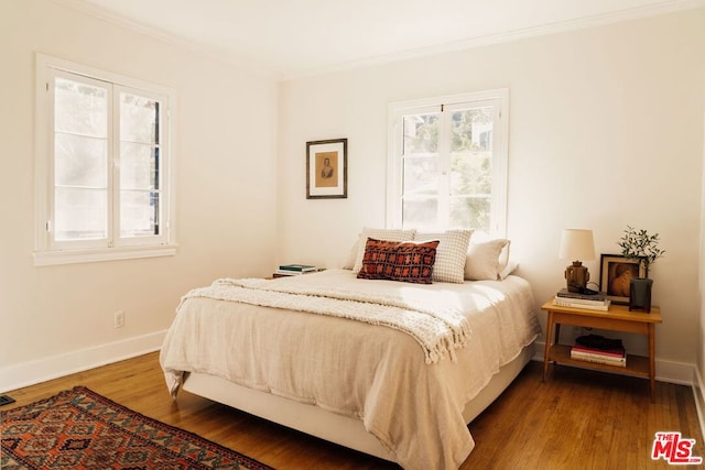 bedroom featuring ornamental molding, hardwood / wood-style floors, and multiple windows