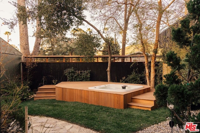 view of yard featuring a wooden deck and an outdoor hot tub