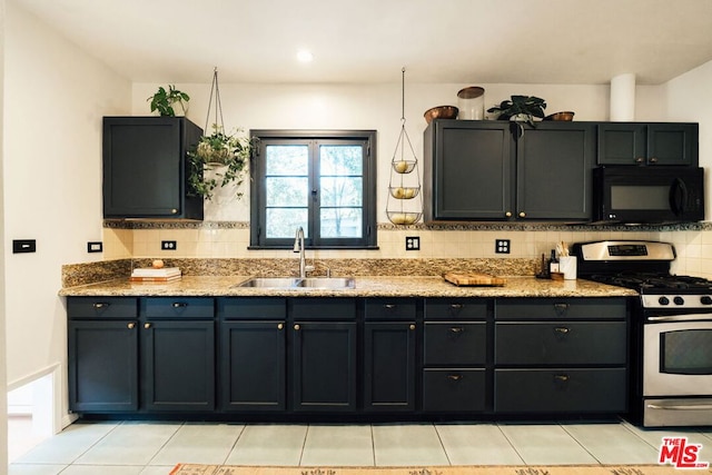 kitchen with backsplash, sink, stainless steel range with gas stovetop, light stone countertops, and light tile patterned floors