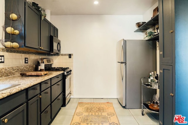 kitchen featuring decorative backsplash, light stone countertops, light tile patterned floors, and stainless steel appliances