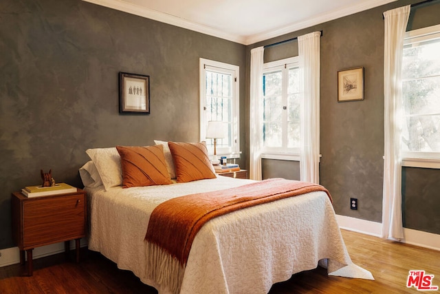 bedroom with crown molding, hardwood / wood-style flooring, and multiple windows