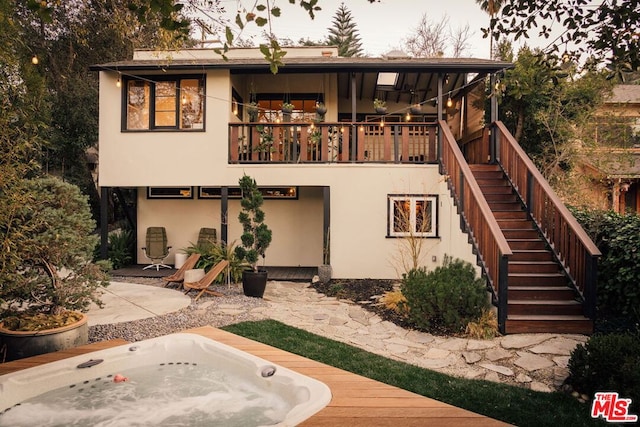 back of house featuring a patio and an outdoor hot tub