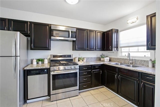 kitchen featuring light tile patterned floors, sink, stainless steel appliances, and dark brown cabinetry