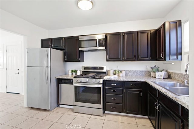 kitchen featuring sink, light tile patterned floors, stainless steel appliances, and dark brown cabinets