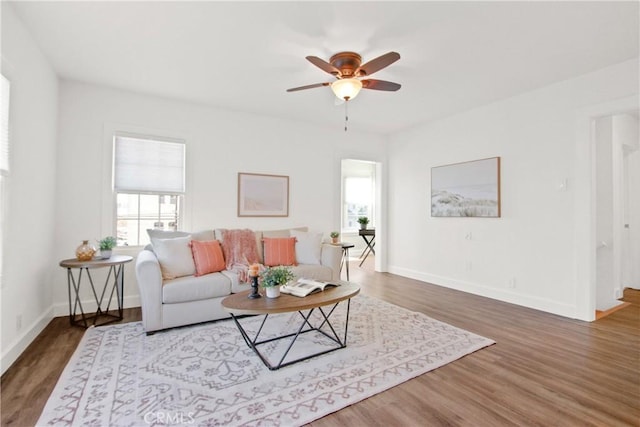 living room with ceiling fan and dark wood-type flooring