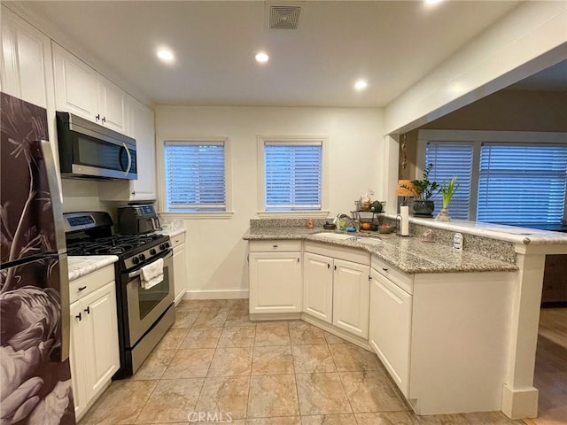 kitchen featuring white cabinetry, sink, kitchen peninsula, and stainless steel appliances