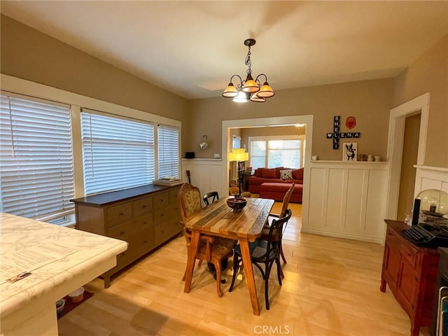 dining space featuring an inviting chandelier and light hardwood / wood-style floors