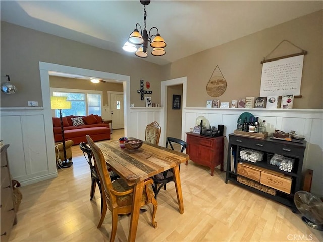 dining space with light hardwood / wood-style flooring and a chandelier