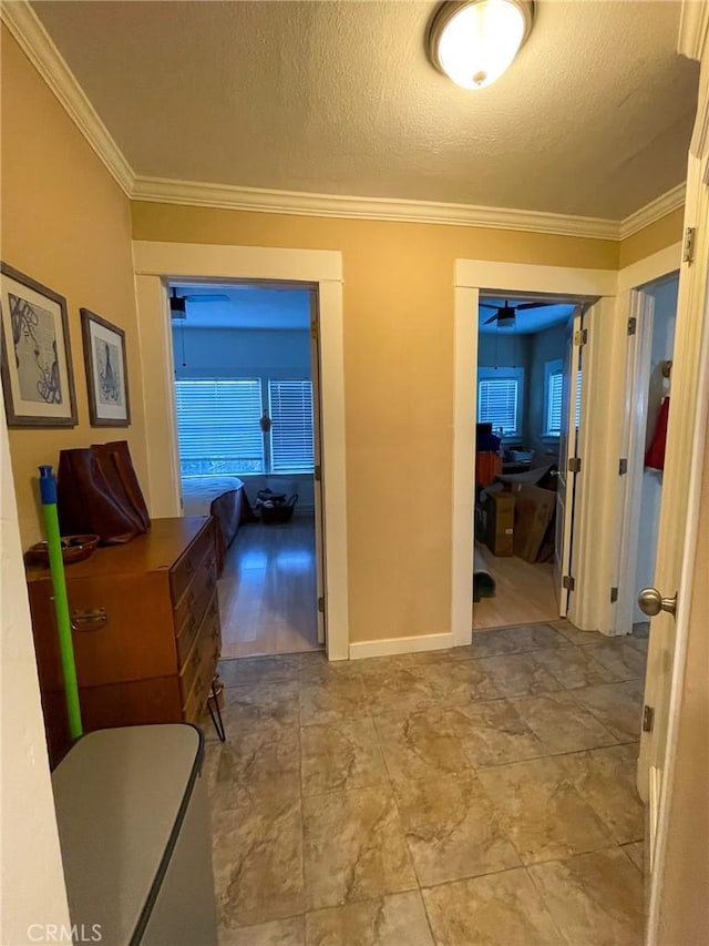 hall featuring a textured ceiling and crown molding