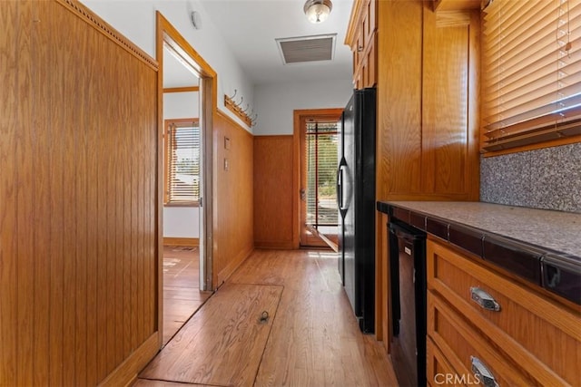 hall featuring wooden walls and light hardwood / wood-style floors