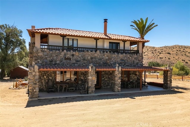 rear view of property featuring a patio area and a mountain view