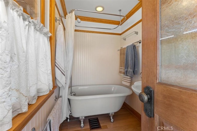 bathroom with a bath and hardwood / wood-style flooring