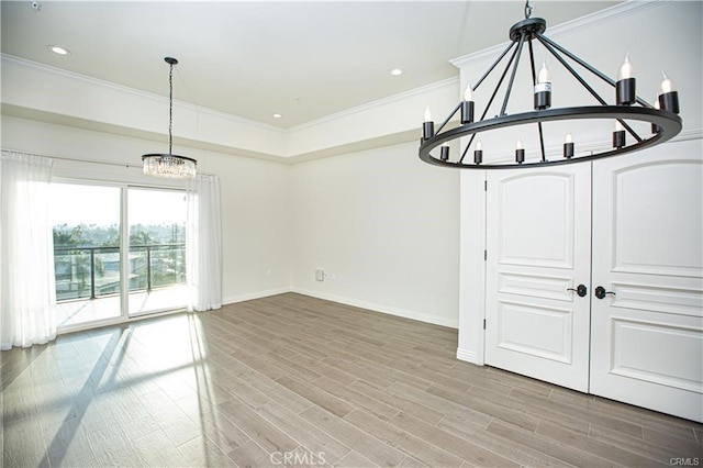 interior space with light hardwood / wood-style floors, crown molding, and a notable chandelier