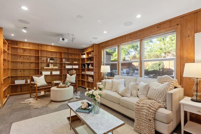 living room with built in features and wooden walls