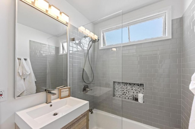 bathroom featuring tiled shower / bath combo and vanity