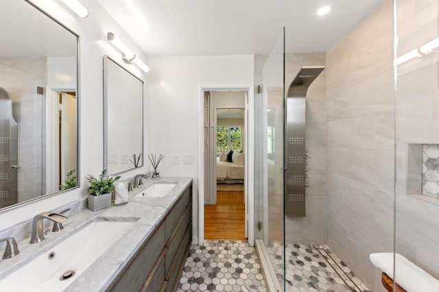 bathroom with walk in shower, vanity, and tile patterned flooring