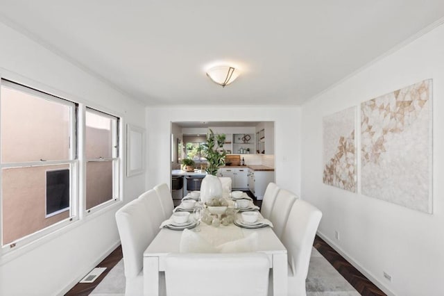 dining area with dark hardwood / wood-style flooring and crown molding