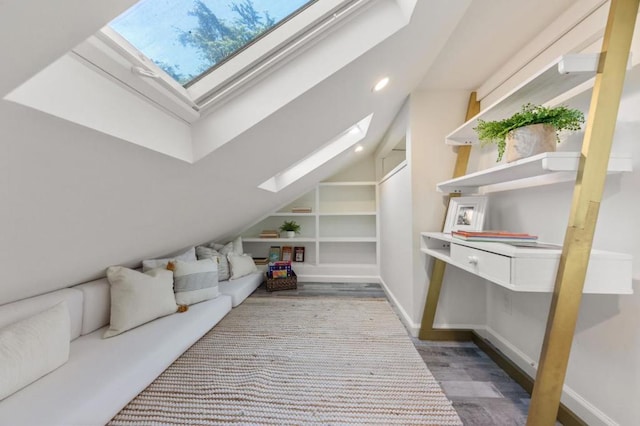 living area featuring lofted ceiling, built in shelves, and wood-type flooring