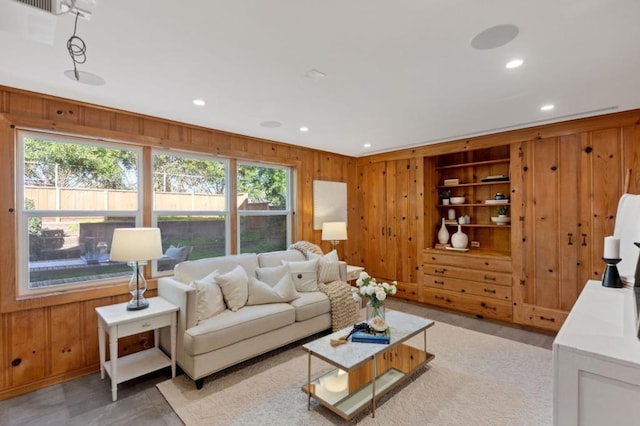 living room with wood walls and built in shelves