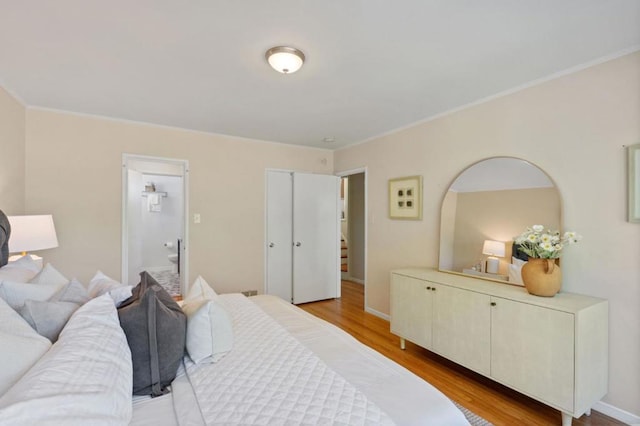 bedroom featuring crown molding and light hardwood / wood-style floors