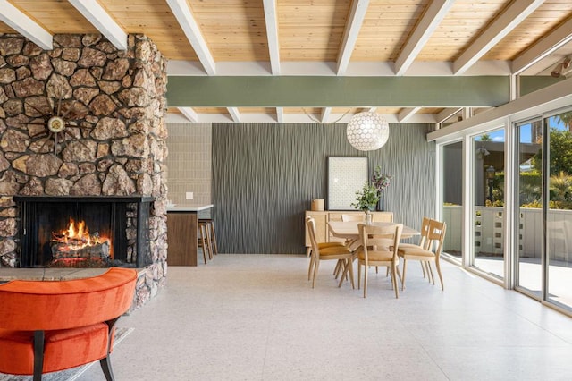 dining space with beamed ceiling and a fireplace