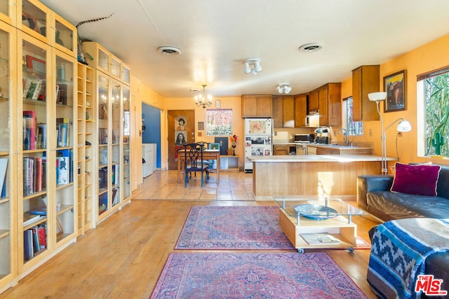 living room featuring light hardwood / wood-style floors, sink, and a notable chandelier