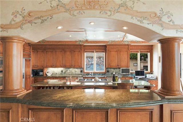 kitchen featuring ornate columns, lofted ceiling, gas stovetop, and decorative backsplash