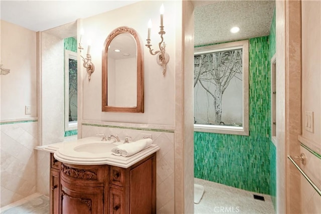 bathroom with vanity, tile patterned floors, and tile walls