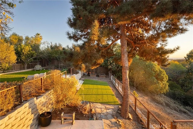 view of community with a fenced backyard and a lawn