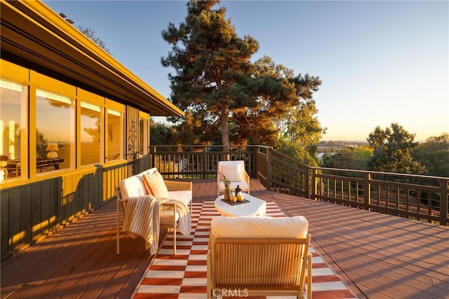 deck at dusk featuring an outdoor hangout area