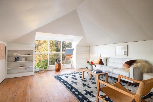 living area featuring vaulted ceiling and wood finished floors