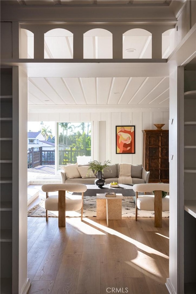 living area with wood finished floors and a decorative wall